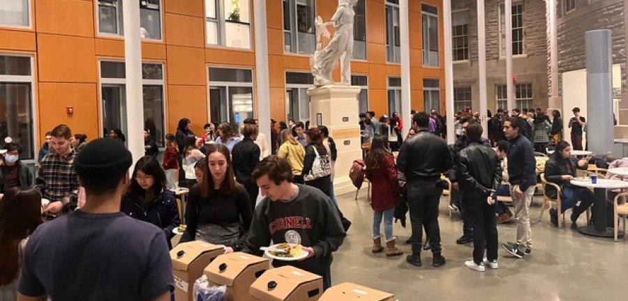 A crowd gathered in Klarman Hall eating and socializing.