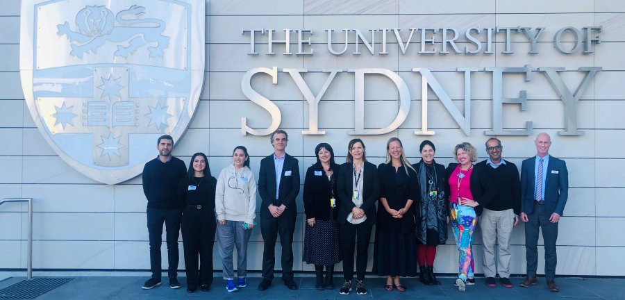 A line of people standing in front of a wall with the Used crest and name.