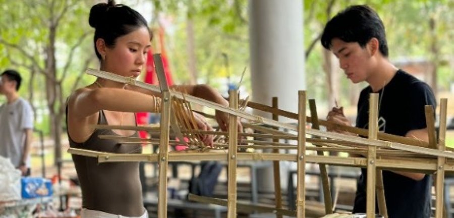 Two students outdoors working on a model.