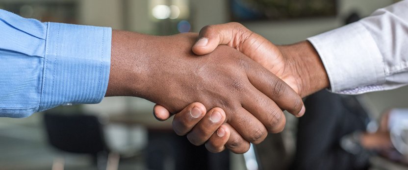 Two hands gripping in a handshake. 