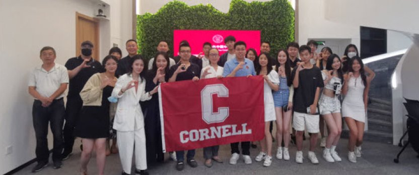 Group of students gathered around Cornell banner