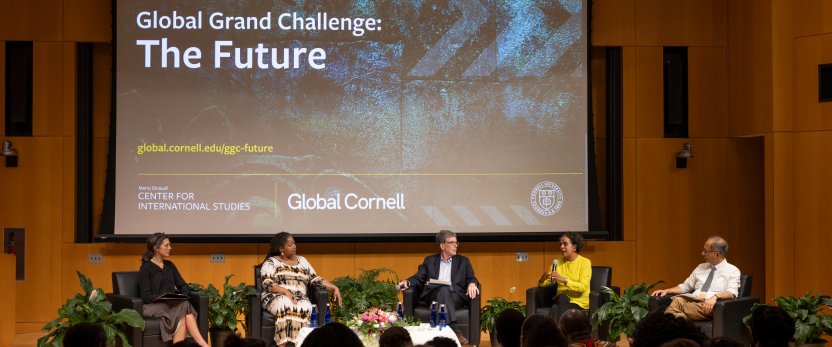 Lecture room with a slide up about the challenge behind a five-person panel. 