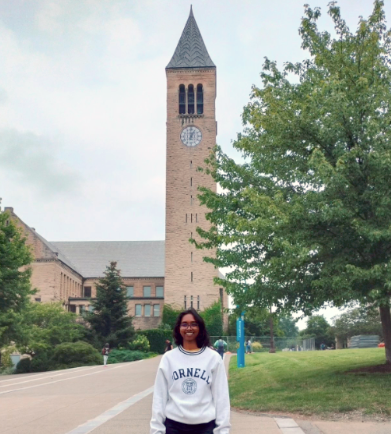 Shwetha Prakash staning in front of the Cornell clock tower.