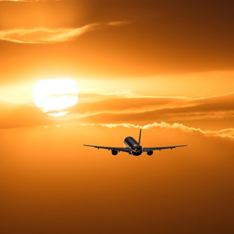 Plane flying towards sun