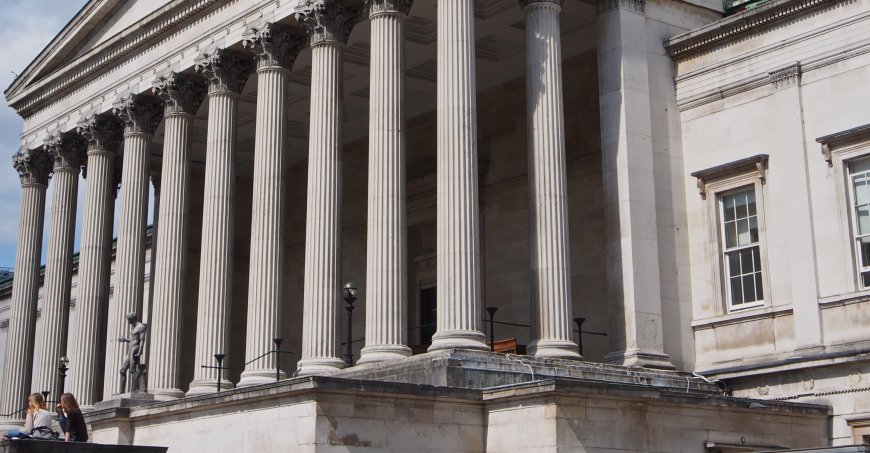 Building with columns and two statues of men with discus. 
