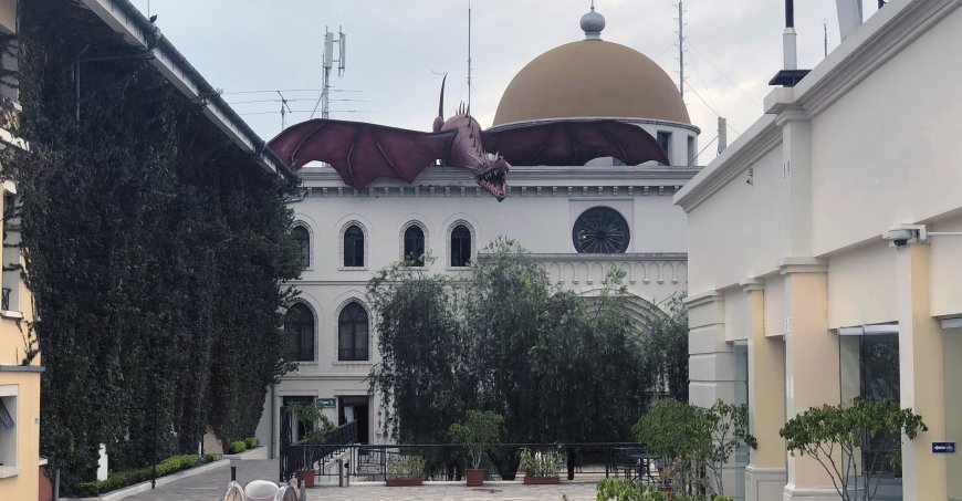 Campus buildings with a sculpted dragon coming over one of the roofs