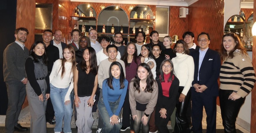  Cornell students with Cornell Club UK alumni pose for a group shot in their facility. 