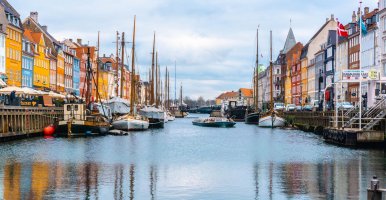 Canal with a variety of boats with colorful buildings on each side.
