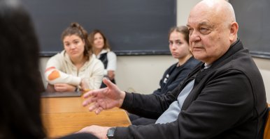 Eugene Nikiforovich in a small classroom setting with students around a table. 