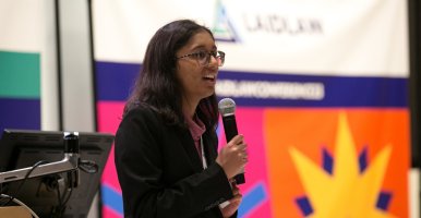 Trisha Bhujle speaks into a microphone. 