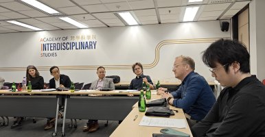 People in discussion, sitting at an L-shaped table.