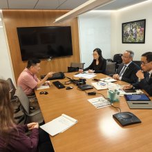 People in a conference space having an animated conversation around the table.