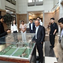 Visitors to Weill Cornell Medicine looking at a minature building in a glass case.