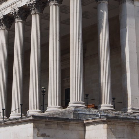 Building with columns and two statues of men with discus. 