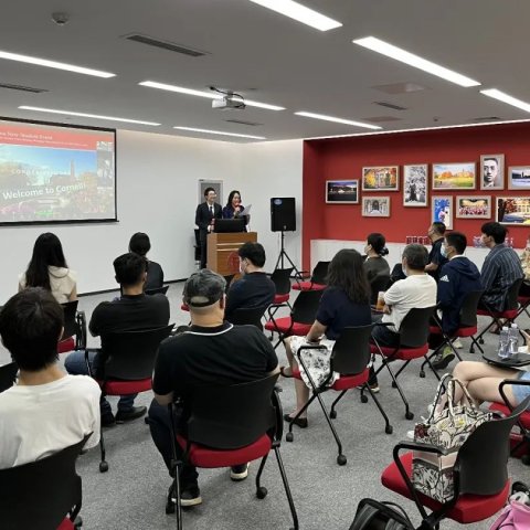 A group sitting in rows listening to a presenter. 