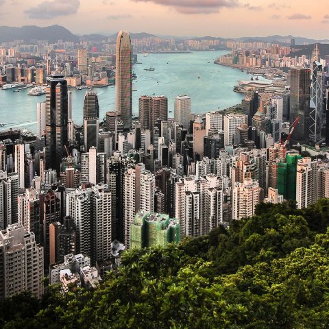View looking down on Hong Kong with the river running through urban sides. 